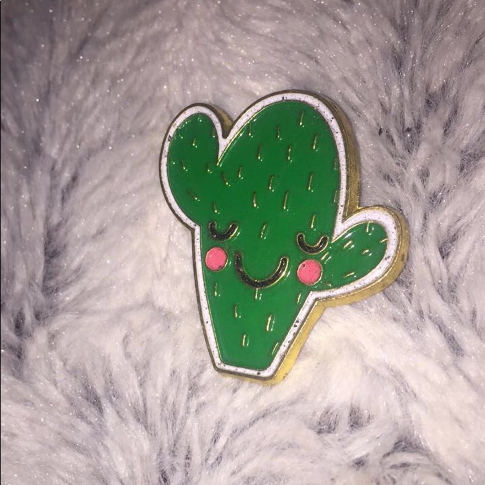 A Cactus Pin with a gold back and a clip